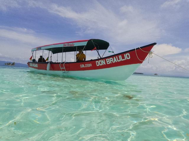 Lancha Don Braulio fondeada sobre agua cristalina en Guna Yala